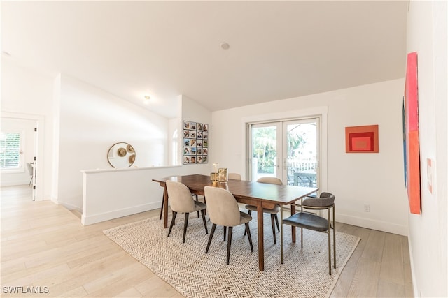 dining room featuring light hardwood / wood-style floors and lofted ceiling