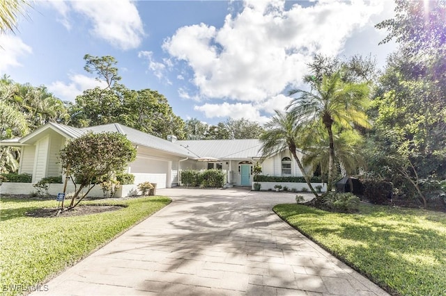 ranch-style house with a garage and a front lawn