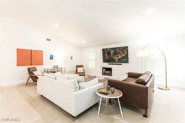 living room featuring vaulted ceiling and light hardwood / wood-style flooring