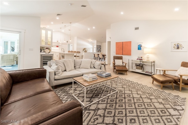 living room featuring vaulted ceiling, wine cooler, and sink