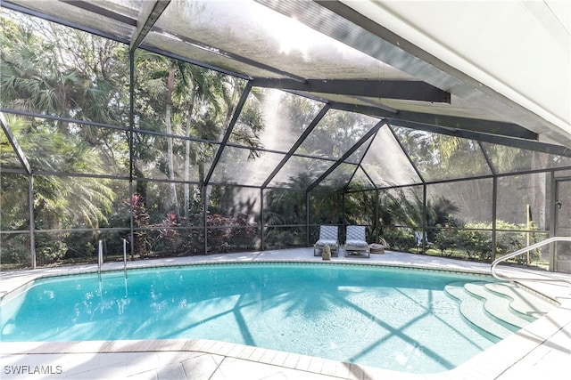 view of swimming pool featuring glass enclosure