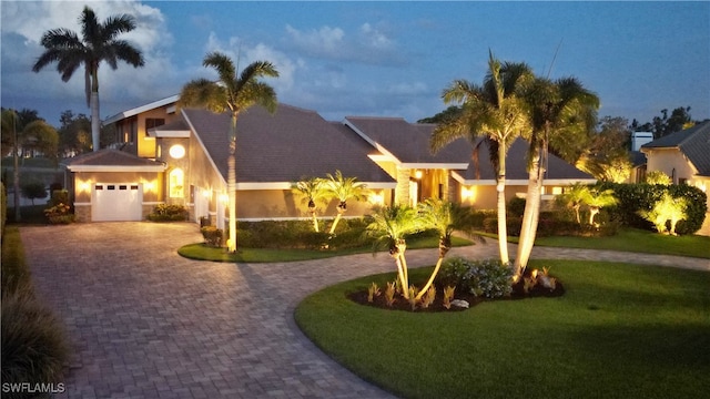 view of front facade with a garage and a lawn