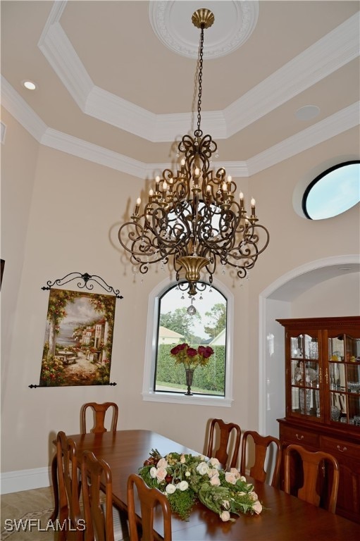 dining room with crown molding, a raised ceiling, and an inviting chandelier