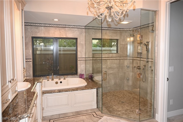 bathroom featuring vanity, independent shower and bath, and an inviting chandelier