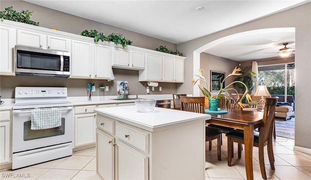 14801 Reflection Key Cir Unit 212, Fort Myers, FL 33907 - kitchen with stainless steel microwave, white range with electric cooktop, light countertops, a ceiling fan, and light tile patterned flooring