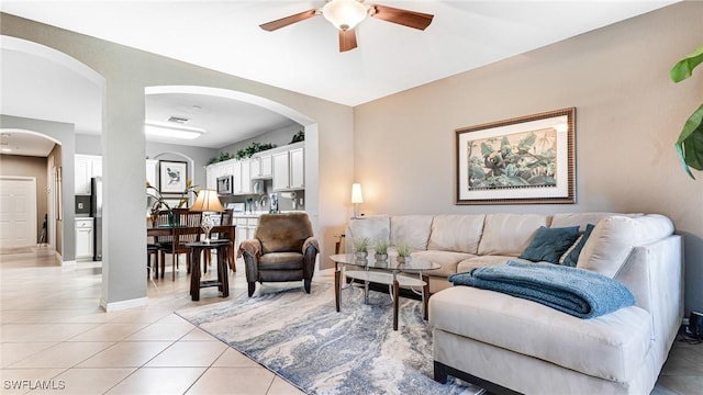 14801 Reflection Key Cir Unit 212, Fort Myers, FL 33907 - living area with light tile patterned flooring, a ceiling fan, arched walkways, and baseboards