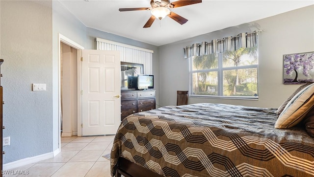 14801 Reflection Key Cir Unit 212, Fort Myers, FL 33907 - bedroom featuring light tile patterned floors, a textured wall, baseboards, and a ceiling fan