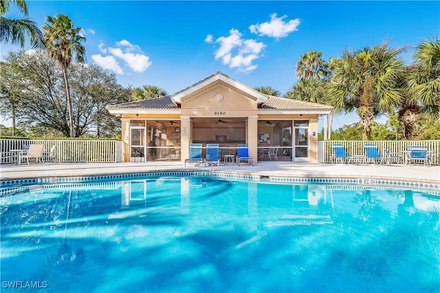 view of swimming pool with a sunroom, ceiling fan, and a patio