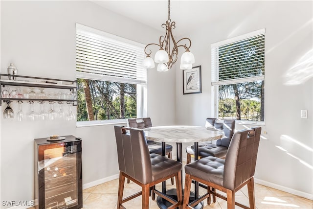 tiled dining space featuring an inviting chandelier and wine cooler