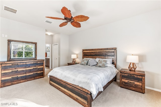 carpeted bedroom with ensuite bath, a closet, and ceiling fan