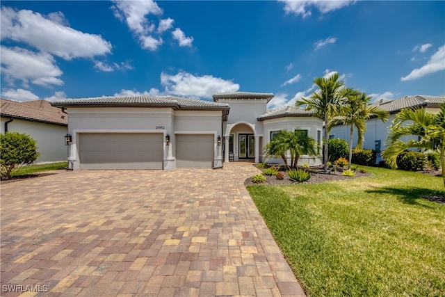 mediterranean / spanish home with a front lawn and a garage