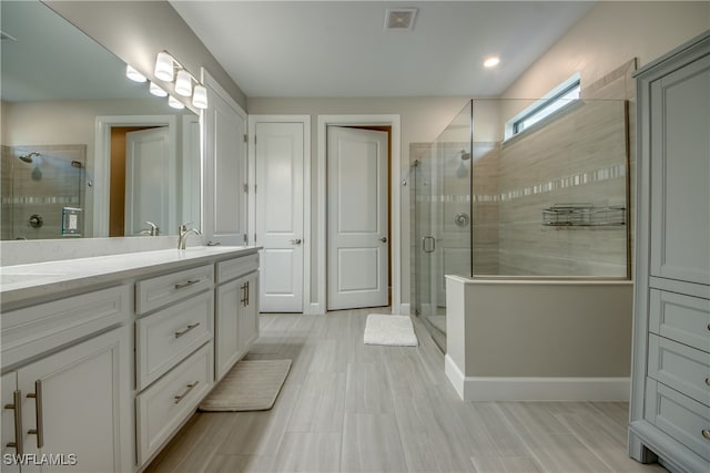 bathroom featuring vanity and an enclosed shower