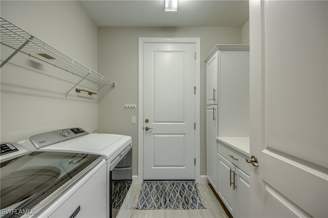 washroom featuring light hardwood / wood-style floors, cabinets, and separate washer and dryer