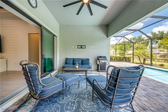 view of patio featuring outdoor lounge area, grilling area, glass enclosure, and ceiling fan