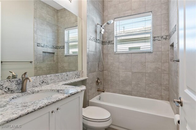 full bathroom with vanity, toilet, and tiled shower / bath