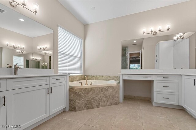 bathroom with tile patterned flooring, vanity, and a relaxing tiled tub