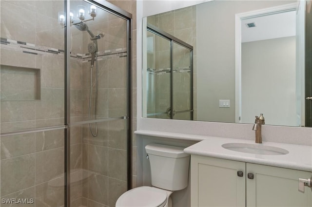 bathroom with toilet, vanity, and walk in shower