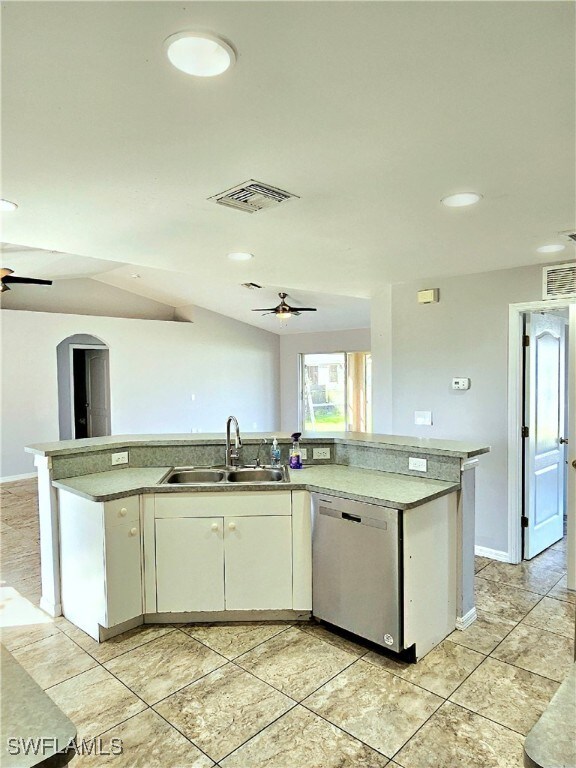 kitchen with dishwasher, an island with sink, sink, white cabinetry, and ceiling fan