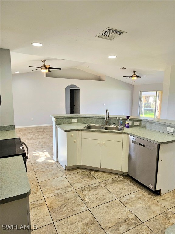 kitchen featuring white cabinets, vaulted ceiling, dishwasher, black range oven, and sink