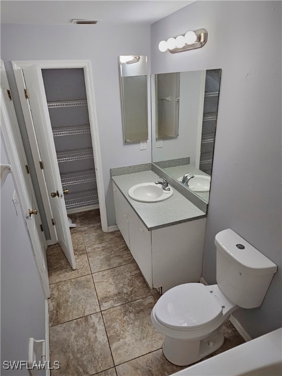 bathroom featuring vanity, toilet, and tile patterned flooring