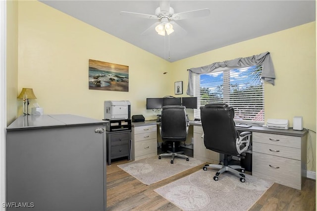 home office featuring lofted ceiling, a ceiling fan, and wood finished floors