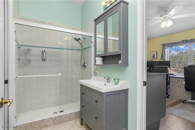 full bathroom with a stall shower, a ceiling fan, and vanity