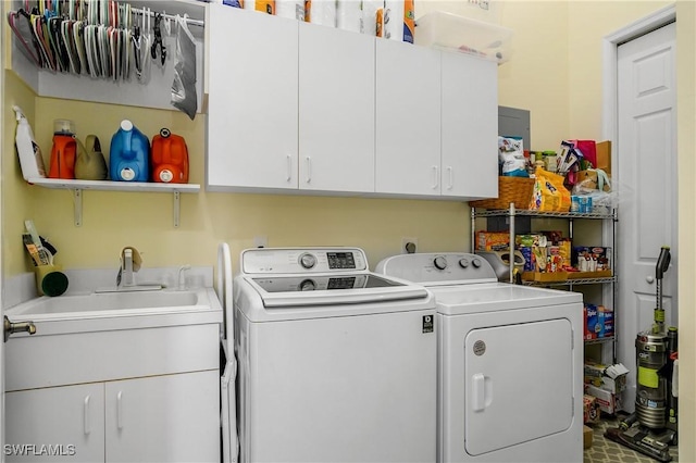 clothes washing area featuring washer and dryer, cabinet space, and a sink