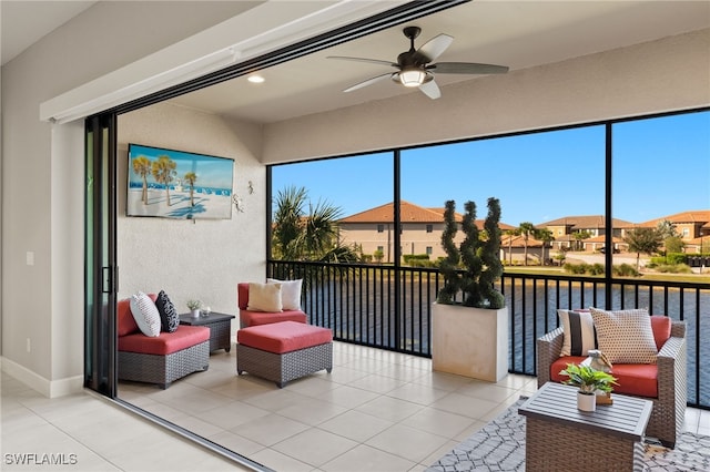 sunroom / solarium with ceiling fan, a water view, and a healthy amount of sunlight