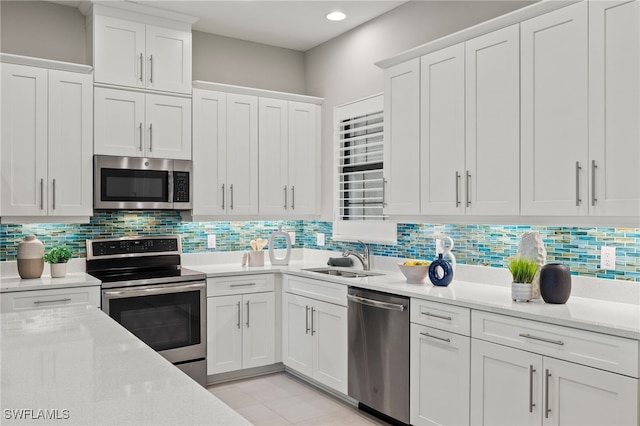 kitchen featuring white cabinetry, sink, backsplash, and appliances with stainless steel finishes