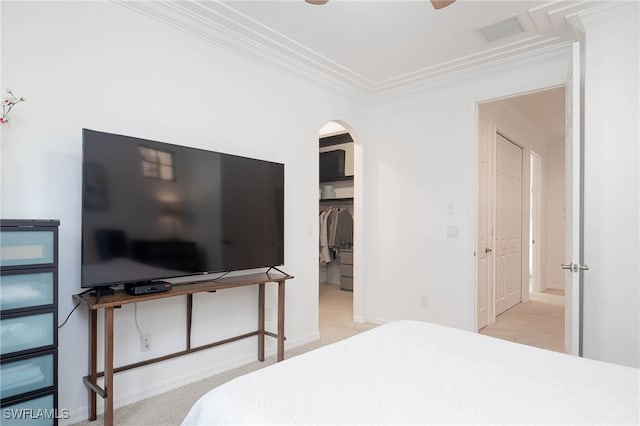 carpeted bedroom with ceiling fan, crown molding, and a closet