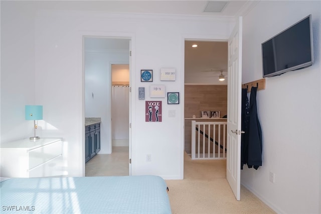 carpeted bedroom with ensuite bathroom and ornamental molding