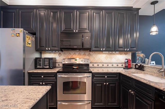 kitchen with light stone counters, hanging light fixtures, black appliances, sink, and tasteful backsplash