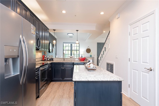 kitchen with ornamental molding, appliances with stainless steel finishes, decorative light fixtures, and a kitchen island