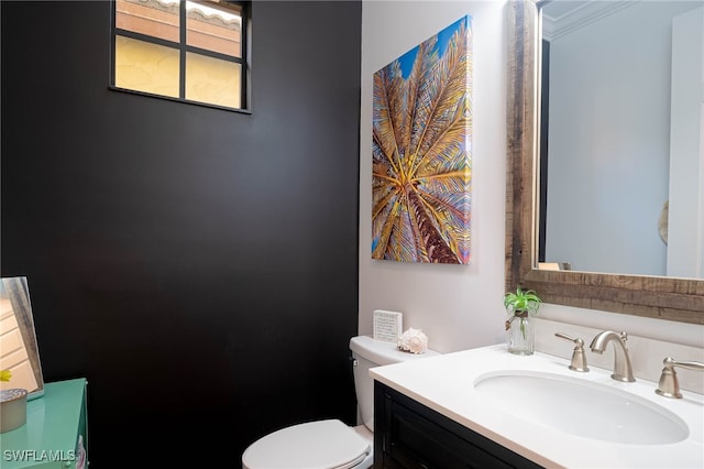 bathroom with vanity, toilet, and crown molding