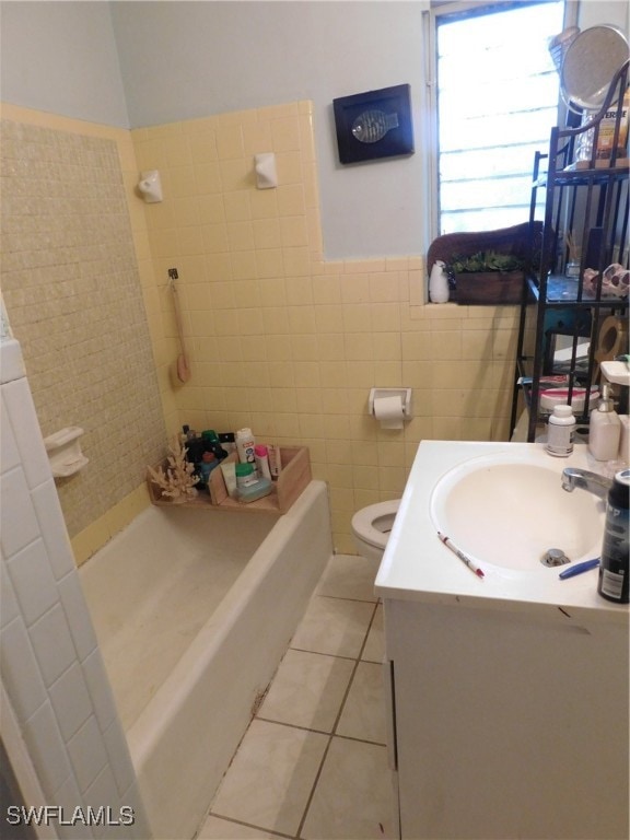 bathroom with tile walls, vanity, toilet, and tile patterned flooring