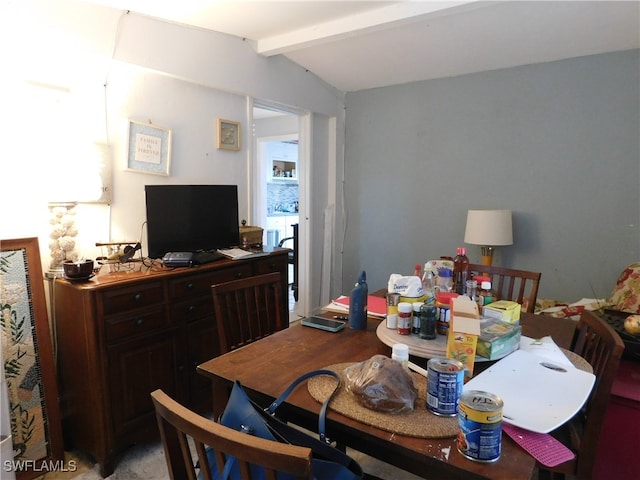 dining room featuring lofted ceiling with beams