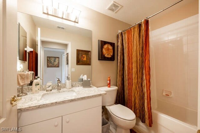 full bathroom with vanity, shower / bath combo, and toilet