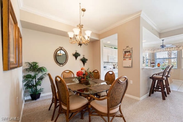 carpeted dining space featuring ornamental molding and ceiling fan with notable chandelier