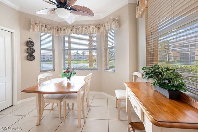 tiled dining space featuring crown molding and ceiling fan