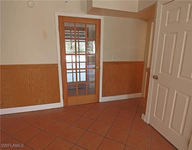 spare room featuring wooden walls and tile patterned floors