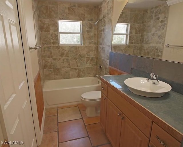 full bathroom with tiled shower / bath, vanity, tile patterned floors, toilet, and tile walls