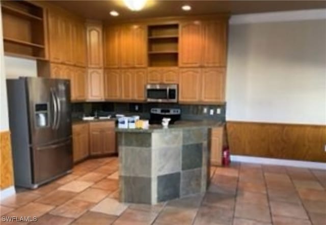 kitchen featuring appliances with stainless steel finishes, tasteful backsplash, and a kitchen island