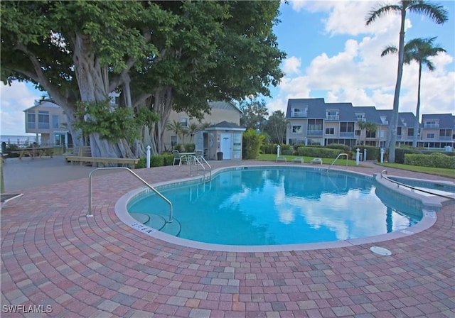 view of swimming pool with an outdoor structure and a patio