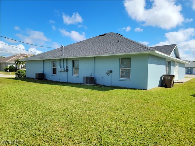 rear view of house with a lawn and central AC unit