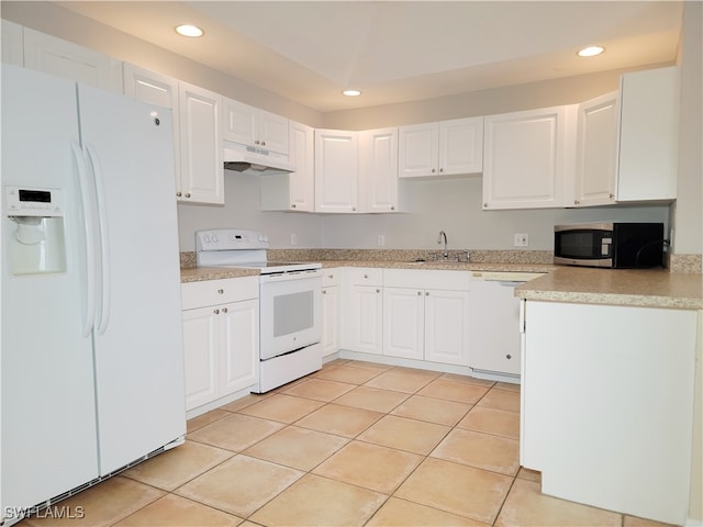 kitchen featuring white appliances, light tile patterned floors, and white cabinets