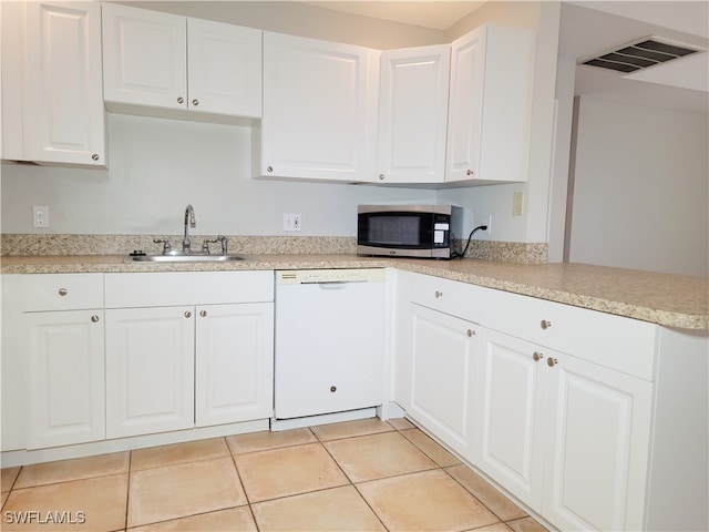 kitchen with sink, dishwasher, white cabinetry, and light tile patterned floors