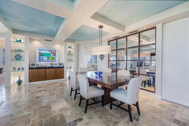 dining space featuring coffered ceiling and built in features