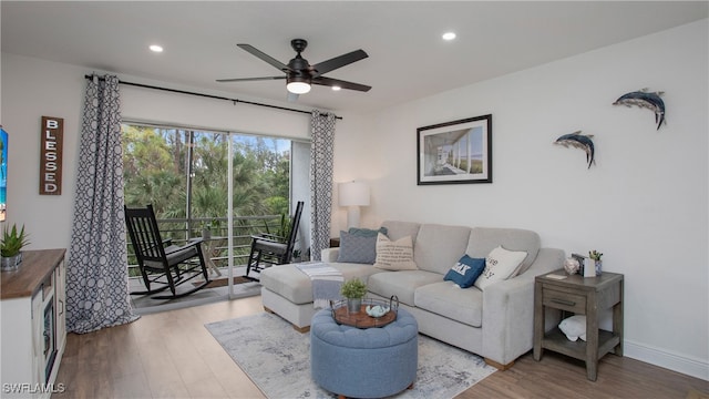 living room with light hardwood / wood-style flooring and ceiling fan