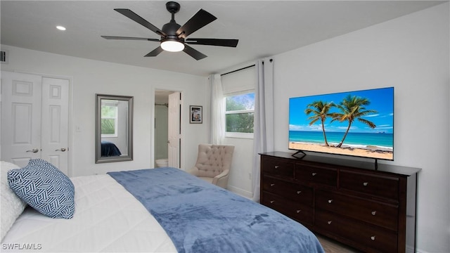 bedroom featuring a closet, ceiling fan, and ensuite bath