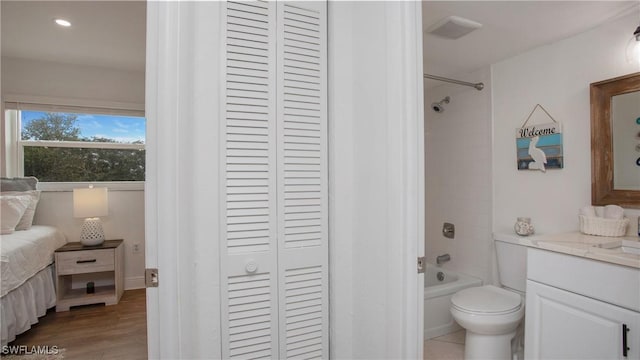 full bathroom with vanity, toilet, wood-type flooring, and tiled shower / bath combo